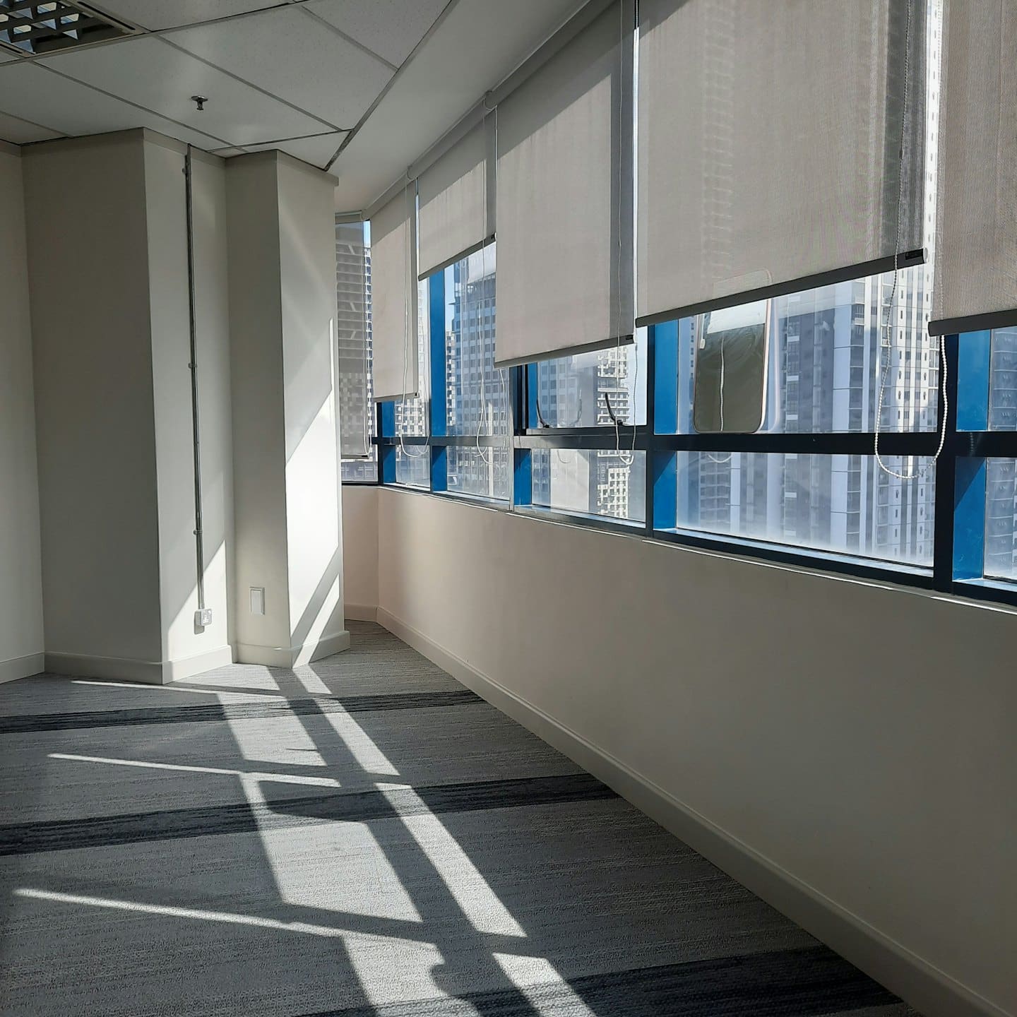 Ufficio moderno e vuoto con finestre che si affacciano sullo skyline della città.